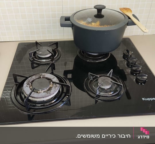 כיריים גז עם סיר ומכסה במטבח ביתי